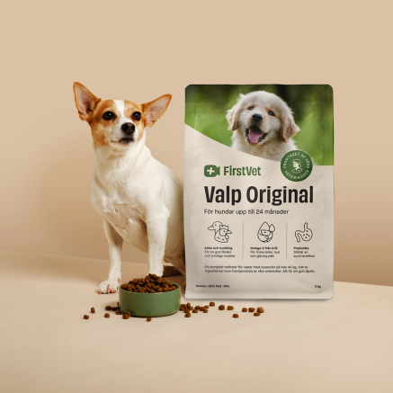 Hunden Doris poserar bredvid en påse FirstVet Valp