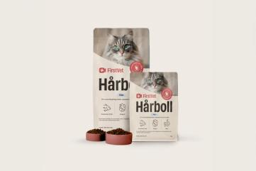Påsar med kattmat från FirstVet Hårboll. Med rosa, fyllda matskålar framför. 
