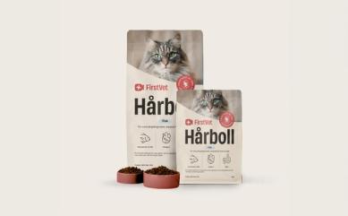 Påsar med kattmat från FirstVet Hårboll. Med rosa, fyllda matskålar framför.
