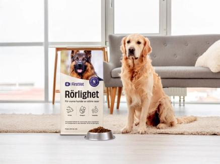 En golden retriever bredvid en påse av hundmaten "Rörlighet" från FirstVet 