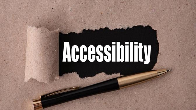 Accessibility word written on brown background with pen in front