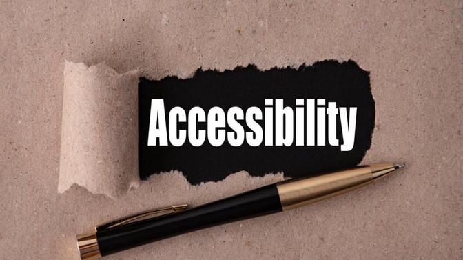 Accessibility word written on brown background with pen in front