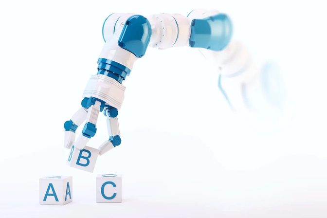 A robotic arm carefully stacks colorful blocks with letters on them. The letters spell out 