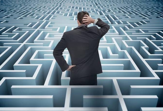 A professional man trying to find his way in a maze of white and blue.
