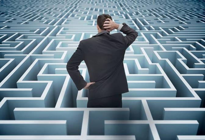 A professional man trying to find his way in a maze of white and blue.
