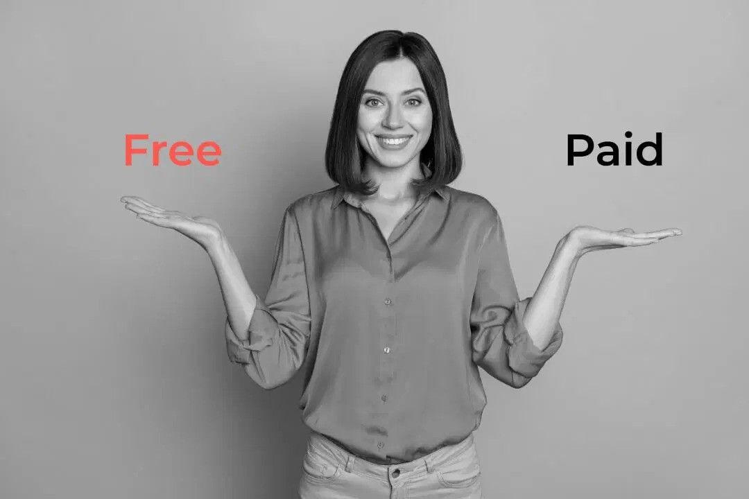 A woman holding up two hands with the words "free" and "paid" written on them.