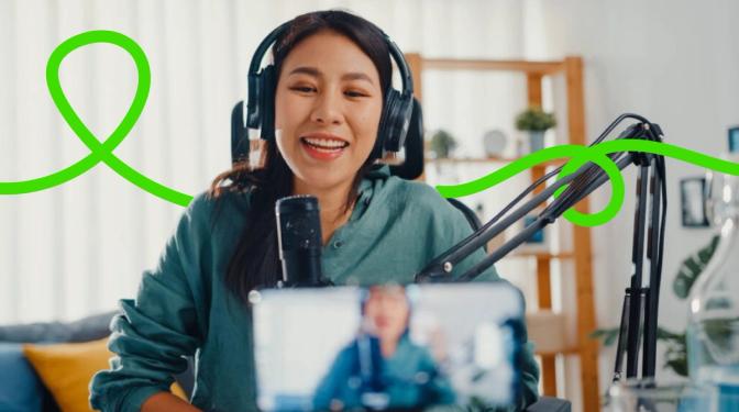 A woman wearing headphones and holding a phone, engrossed in her music and conversation.