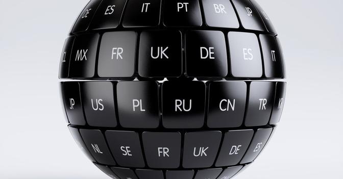 A globe-shaped computer keyboard with keys representing different countries. The letters on the keys show some of the major language groups.