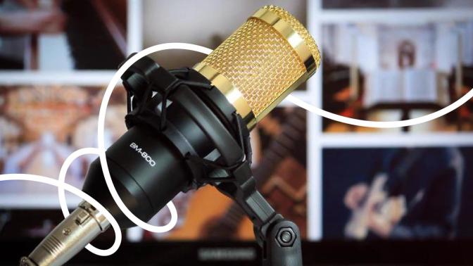 A microphone with a gold cord and various musical instrument pictures on the back.