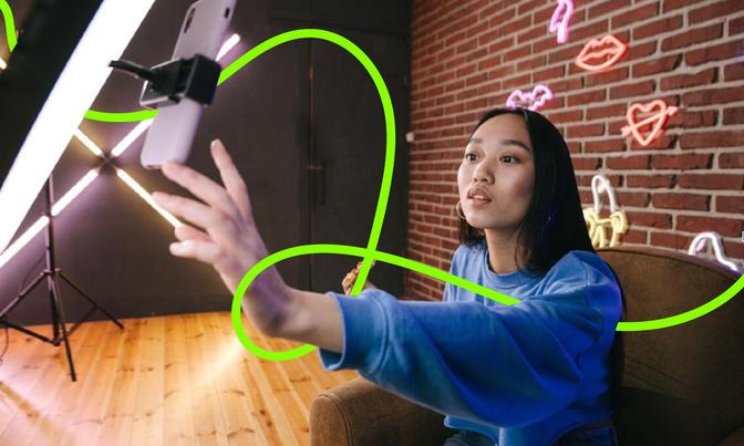 A woman posing for a selfie with a neon light, creating a lively and captivating atmosphere in the picture.