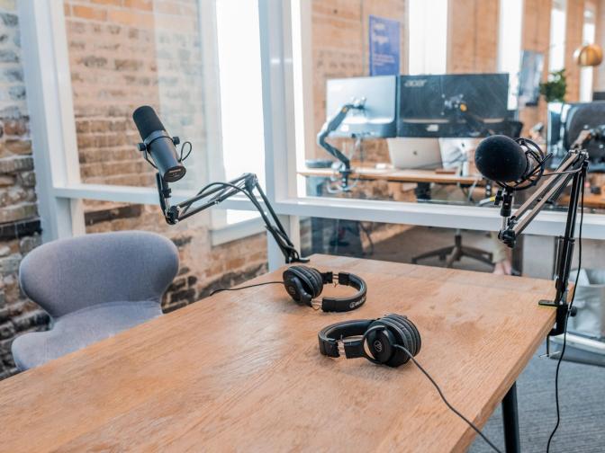 A table with two microphones and a pair of headphones on it.