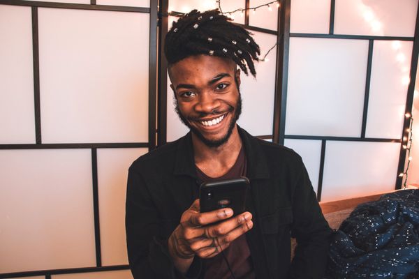 Man smiling and using his mobile phone