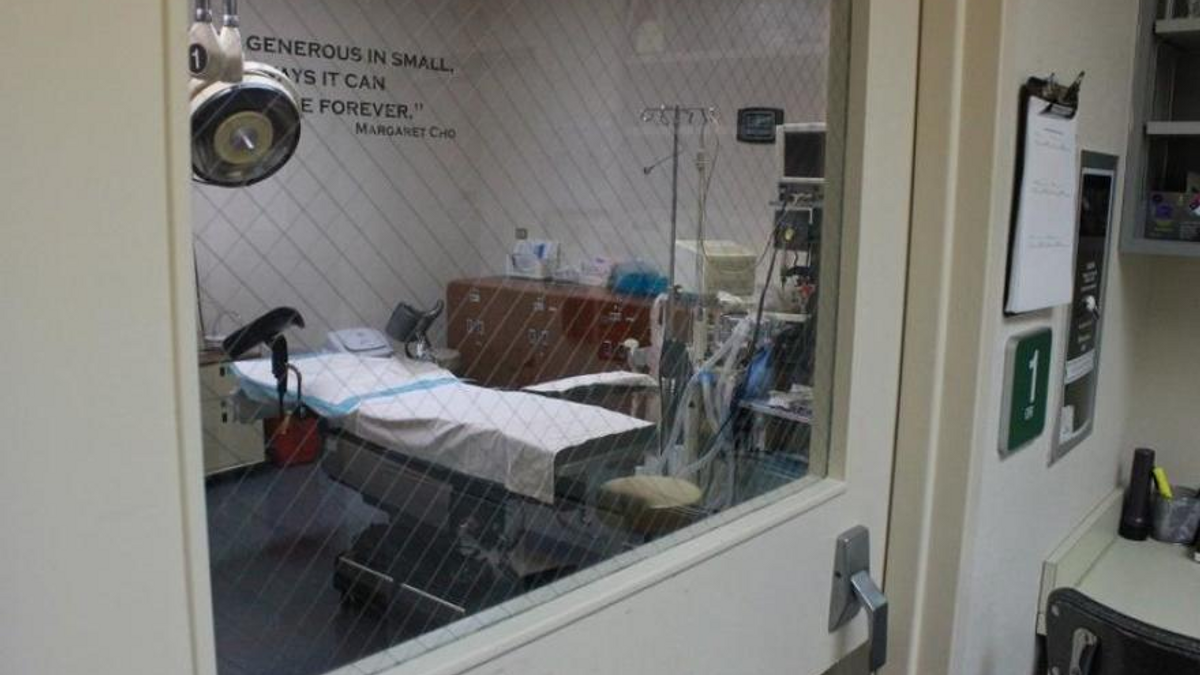 A hospital bed sits empty in a medical facility.