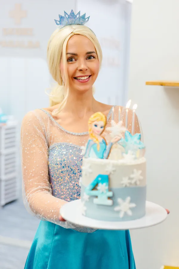 Elza animatorė pozuoja su laimingais vaikais gimtadienio šventėje