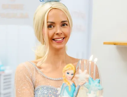 Elza animatorė pozuoja su laimingais vaikais gimtadienio šventėje