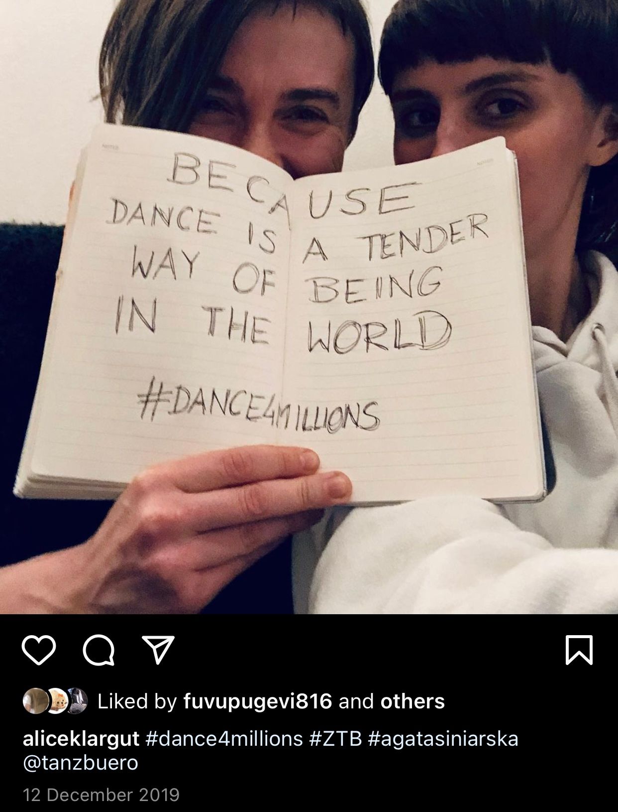 Two people holding a notebook that reads 'Because dance is a tender way of being in the world #dance4millions