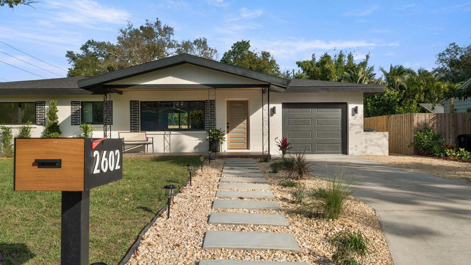 Modern renovated single-story home in Tampa Bay with updated exterior, landscaping, and driveway