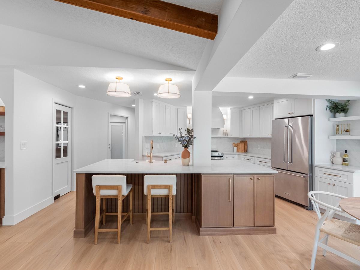 Spacious kitchen with large island seating, custom wood cabinetry, and open layout in renovated Clearwater home