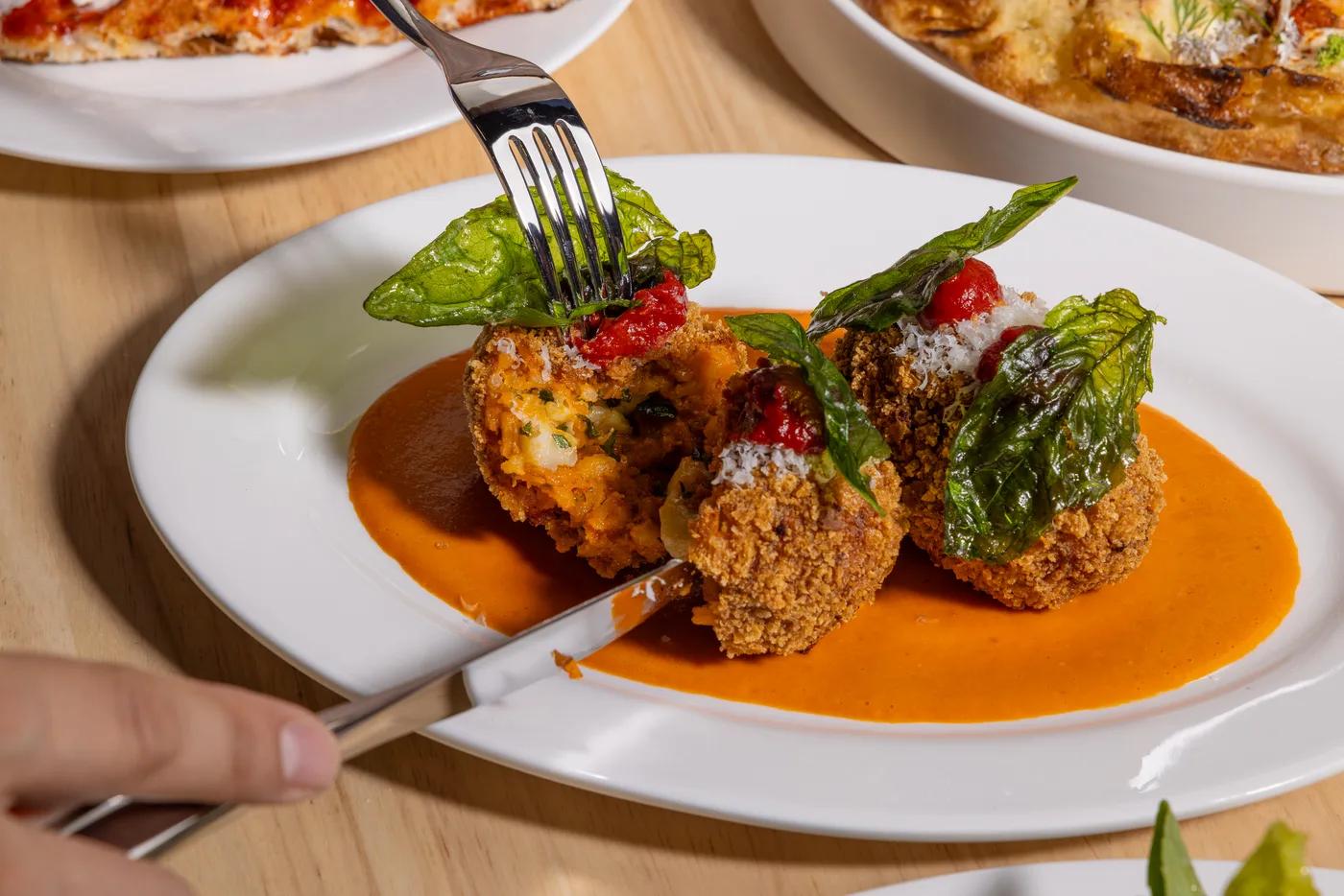 Arancini in a pool of pomodoro