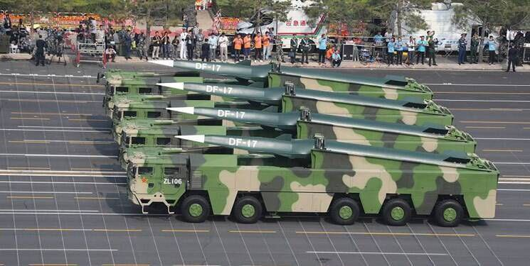 A military parade featuring several large, green camouflage transporter trucks carrying sleek, white-tipped DF-17 hypersonic missiles.