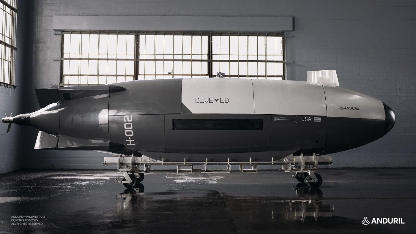 Anduril Dive-LD autonomous undersea vehicle, hull number H-002, on a wheeled cradle inside a hangar