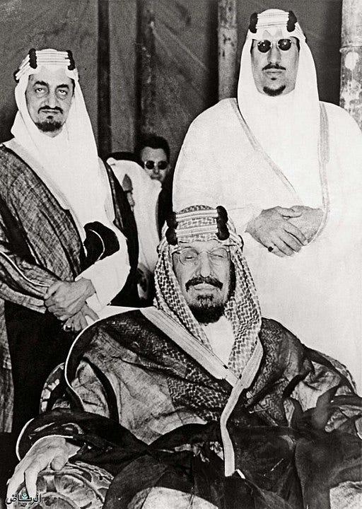 King Abdulaziz (seated), and his sons Saud (Right) and Faisal (Left) pose for a photo together, during Abdulaziz’s reign.
