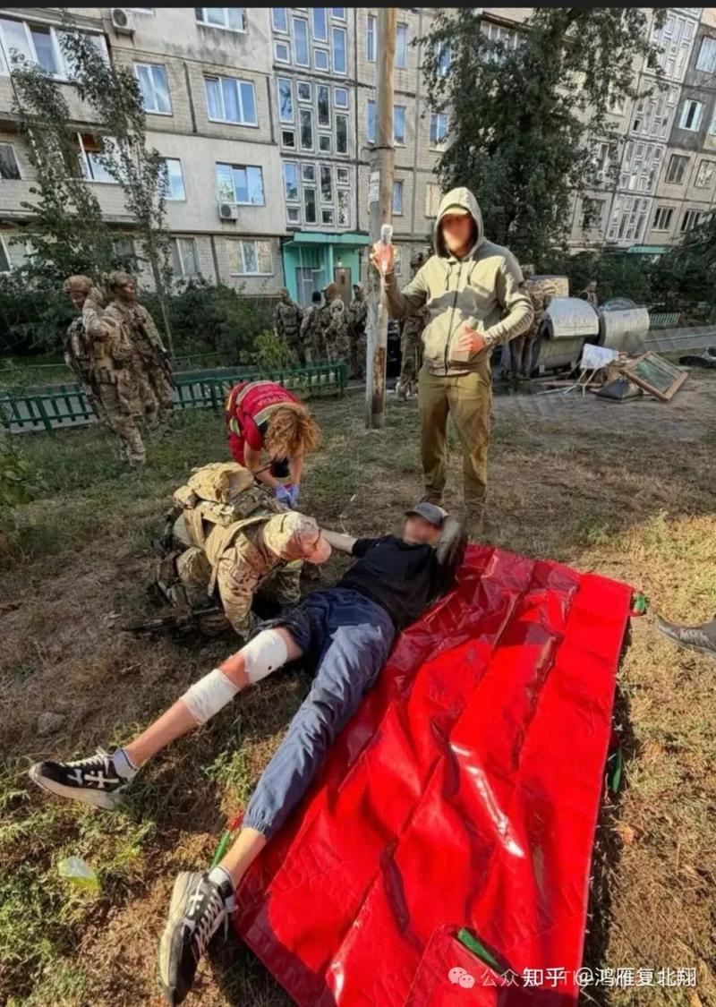 Medics treating a wounded man on a red tarp outside a Kyiv apartment block
