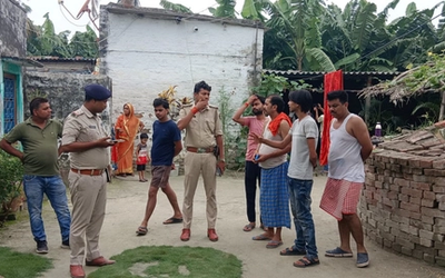 वैशाली के मदारपुर में किराना दुकानदार के घर के बाहर बमबाजी के बाद जांच करती पुलिस और मौके से बरामद सुतली बम।