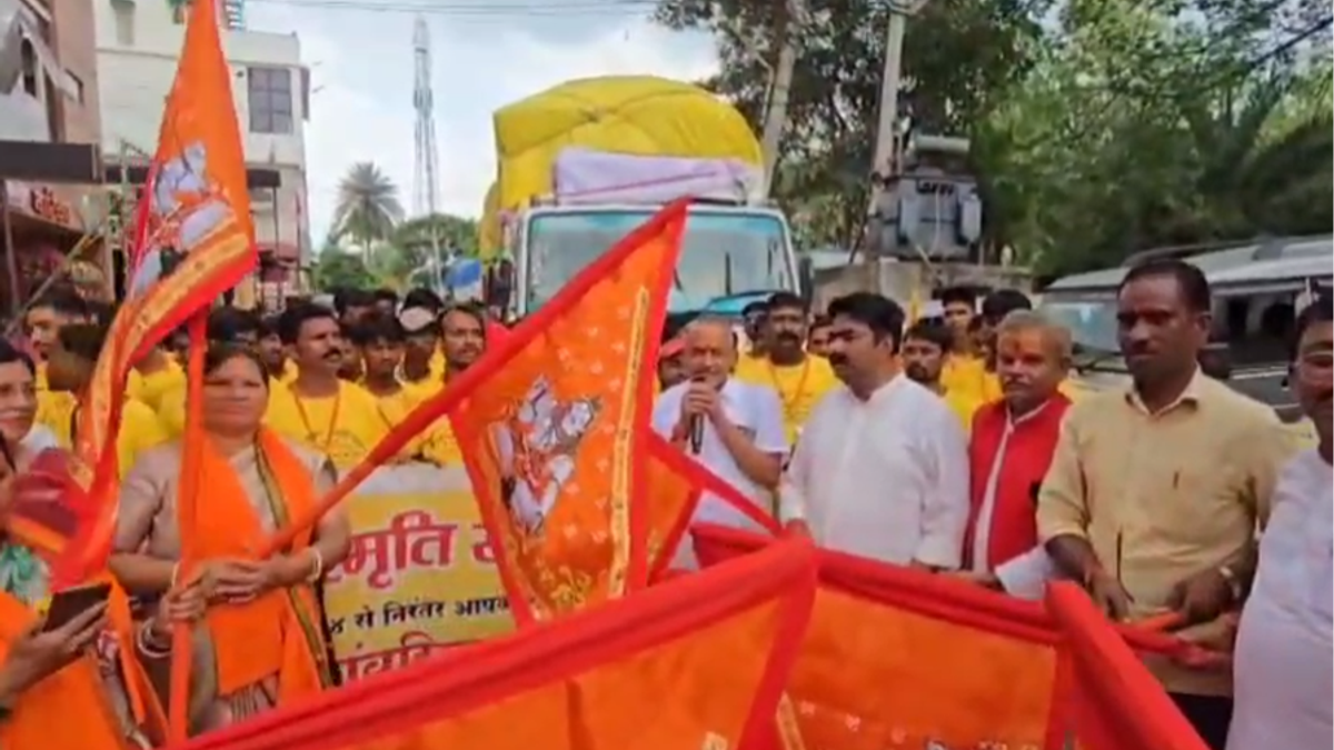 लातेहार से देवघर श्रावणी मेला सेवा शिविर के लिए रवाना होते 75 सदस्यीय सेवा दल को हरी झंडी दिखाते विधायक प्रकाश राम।