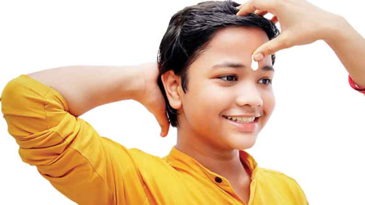 पूजा के बाद माथे पर चंदन का तिलक लगाती महिला