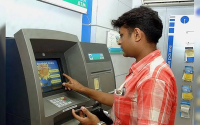 ATM मशीन पर Cash Deposit और अन्य बैंकिंग सेवाओं का उपयोग करते हुए ग्राहक की सांकेतिक तस्वीर।
