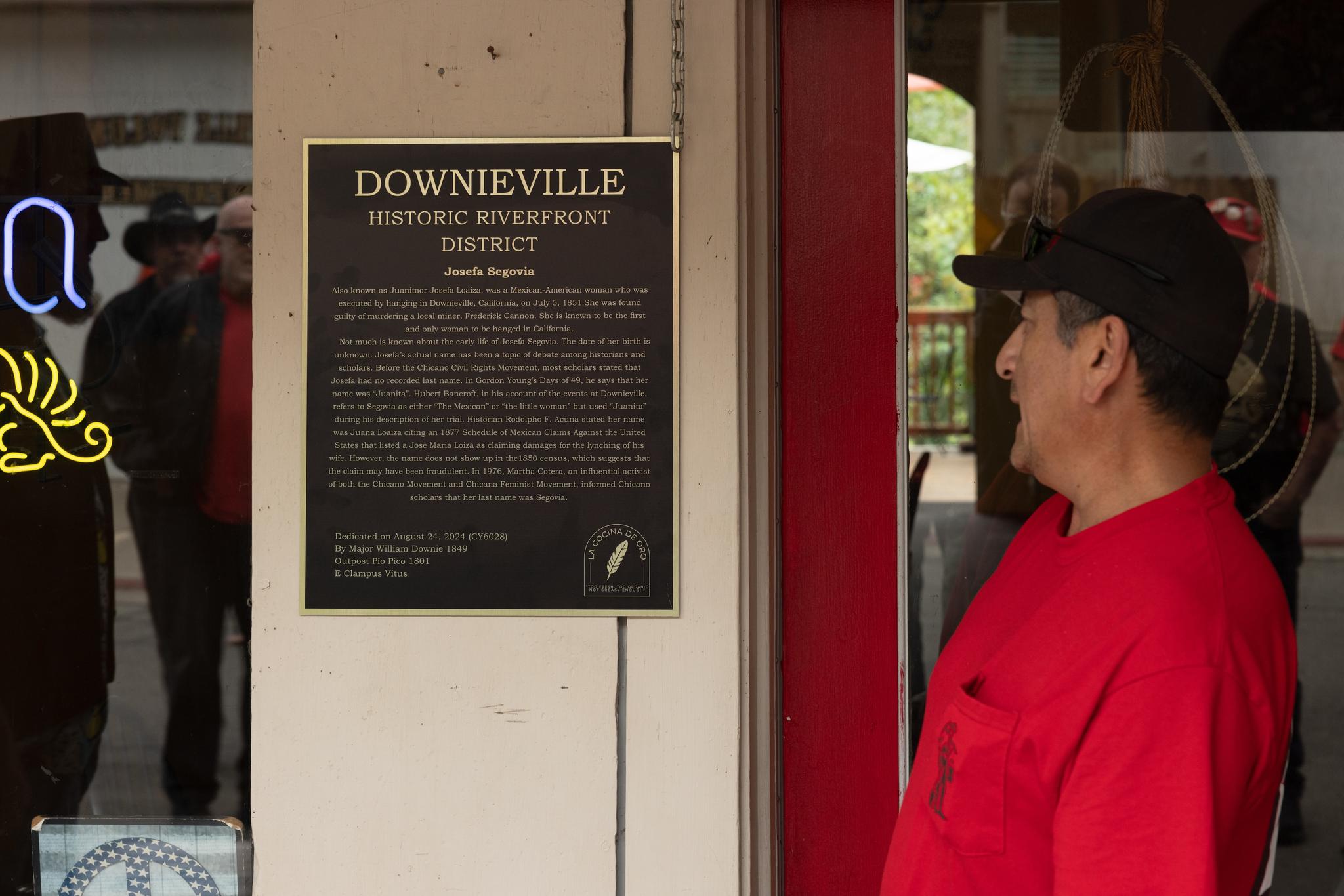 Gil Alvira reads the plaque memorializing Jefa Segovia at La Cocina De Oro