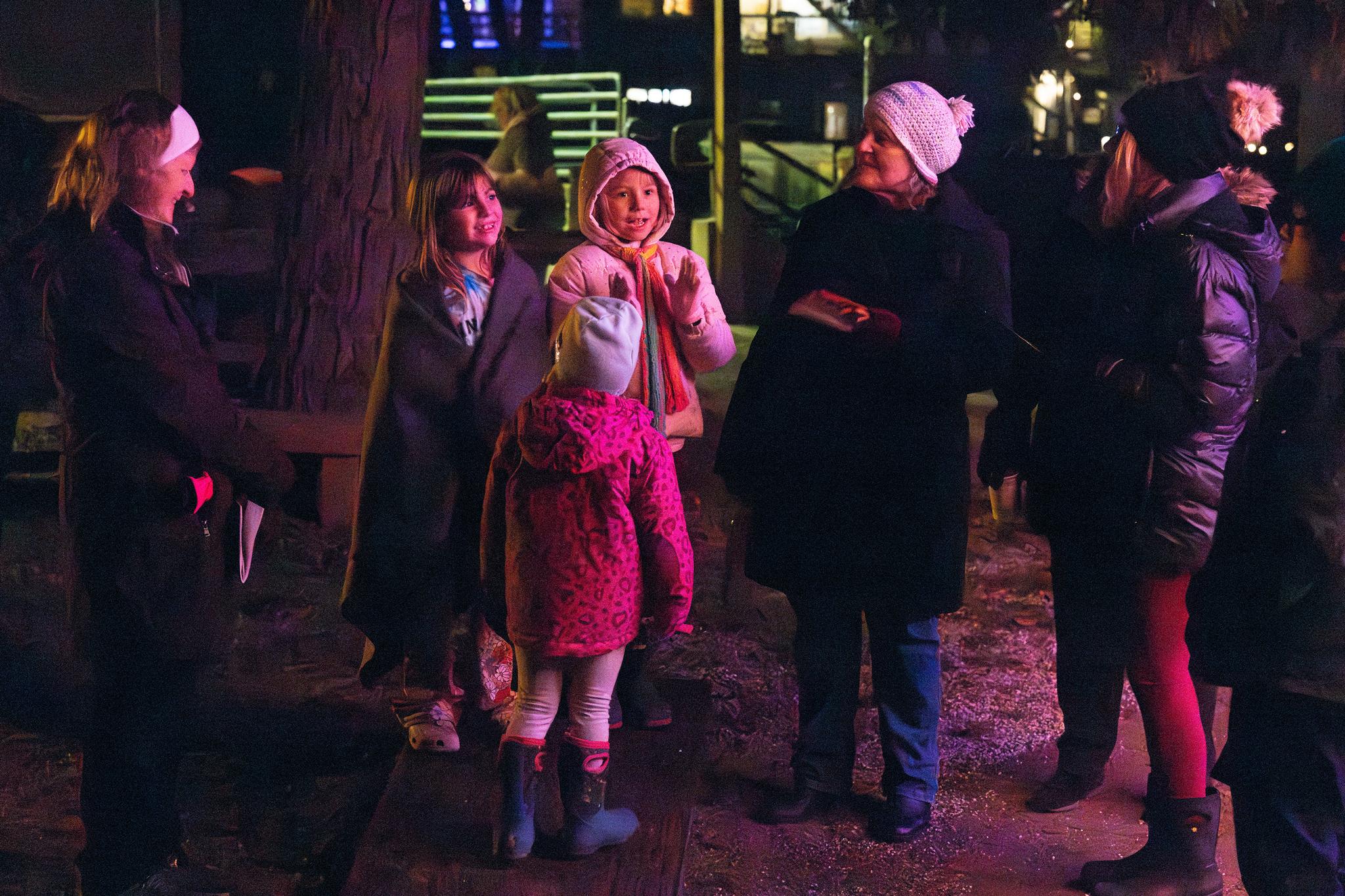 Children carol in anticipation of Santa’s arrival and the lighting of the town tree