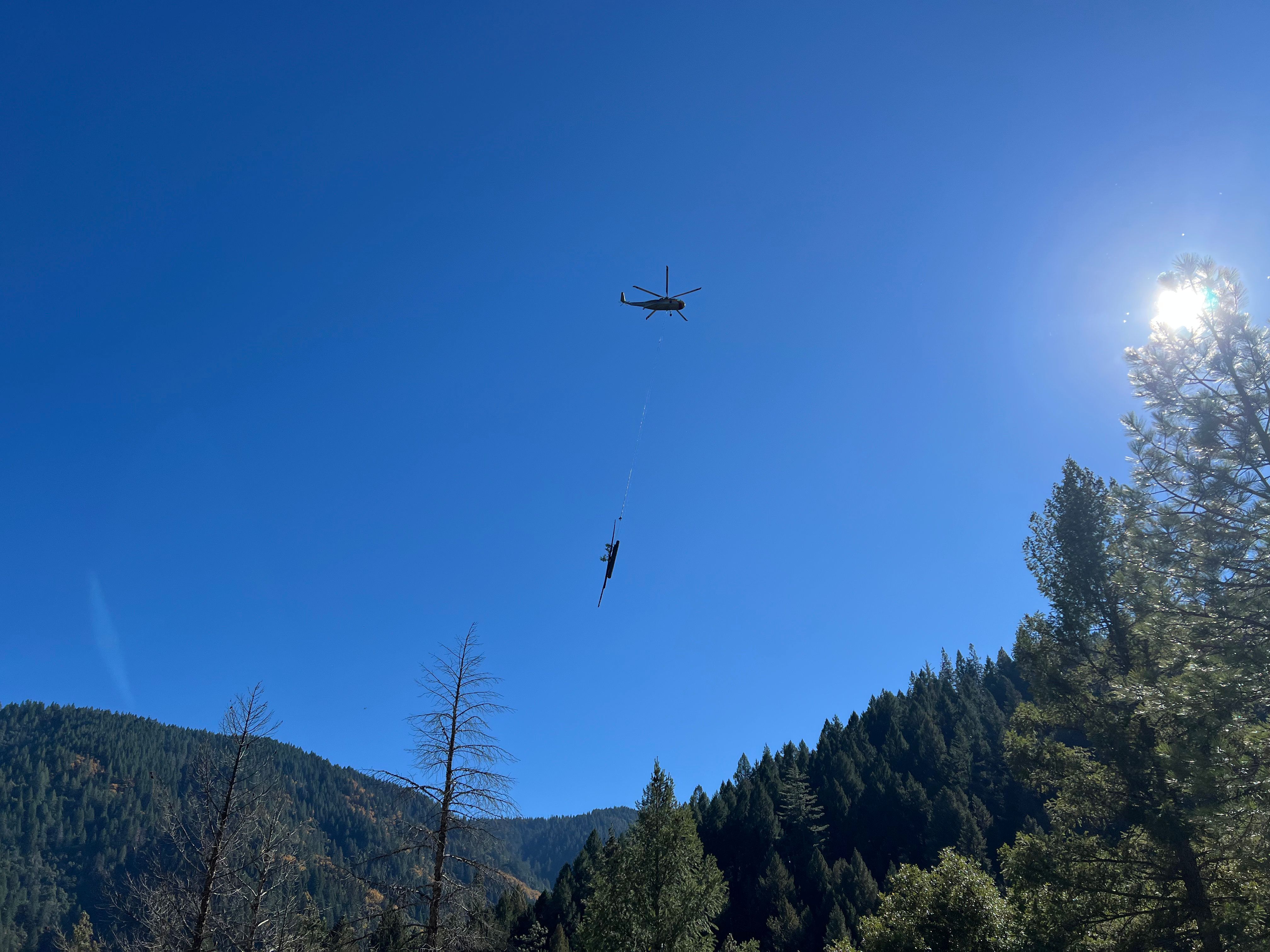 A helicopter carries logs near Goodyears Bar.