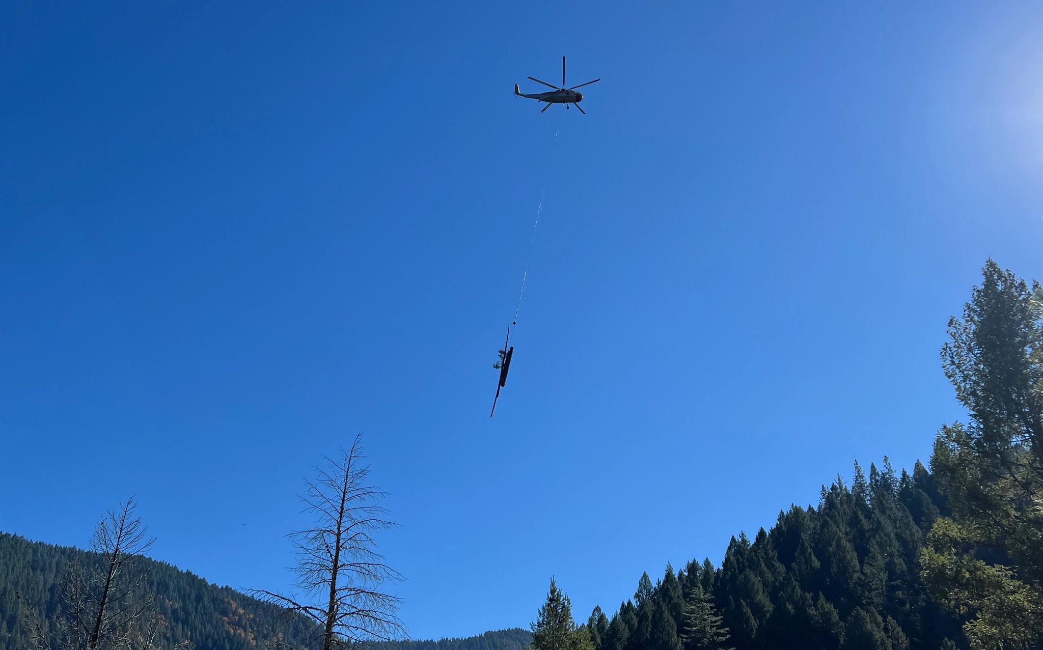 A helicopter carries logs near Goodyears Bar.