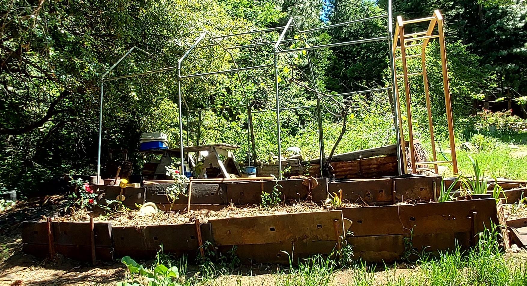 Terraces built with repurposed mill liner plates. The newly planted roses will eventually be trained onto the arbor in the background.