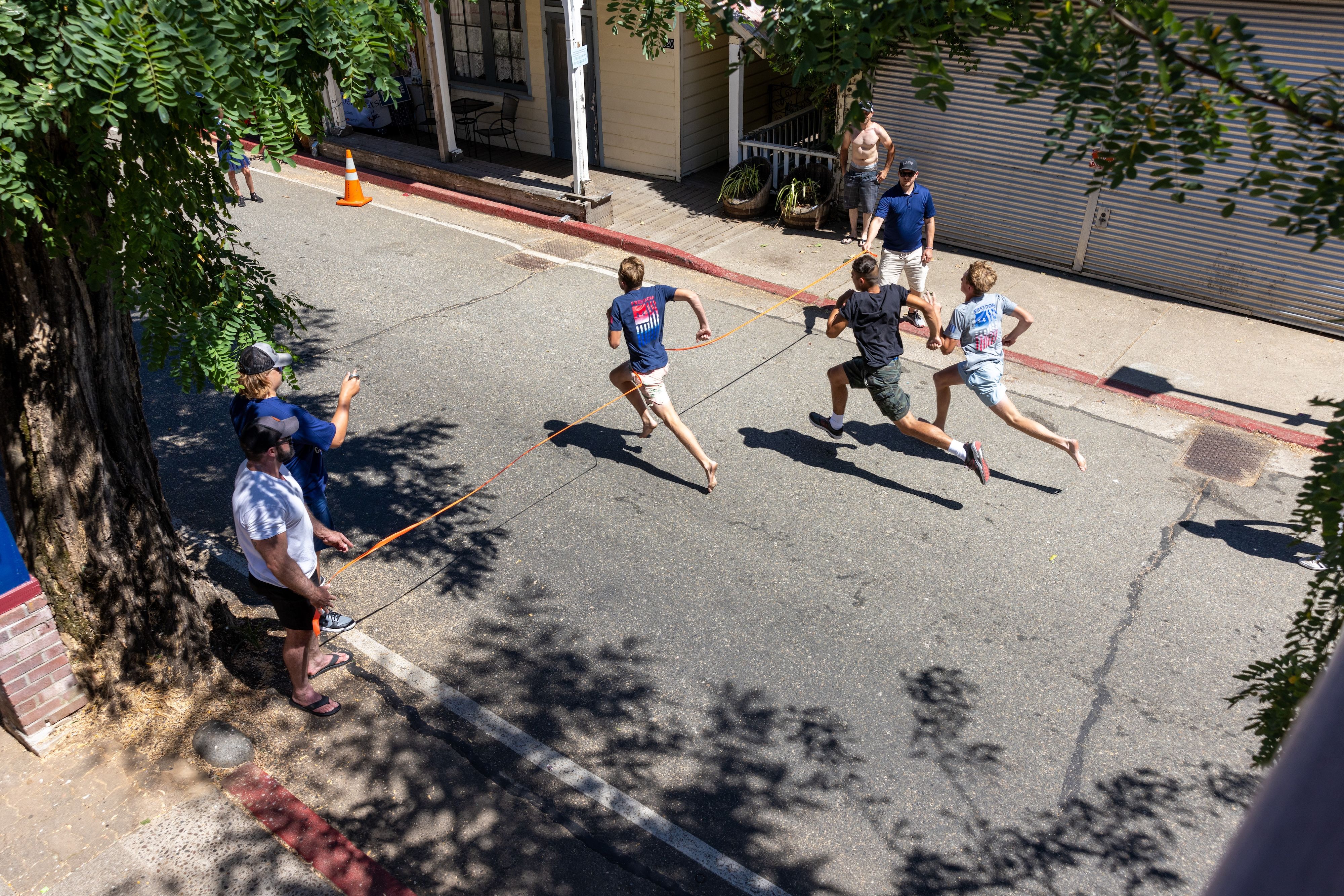 Brady Wells reaches the line first in the 14-year-old boys race, followed by Oscar Kristoferson and Jackson Wells
