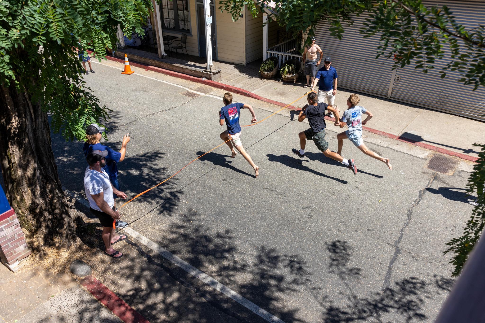 Brady Wells reaches the line first in the 14-year-old boys race, followed by Oscar Kristoferson and Jackson Wells