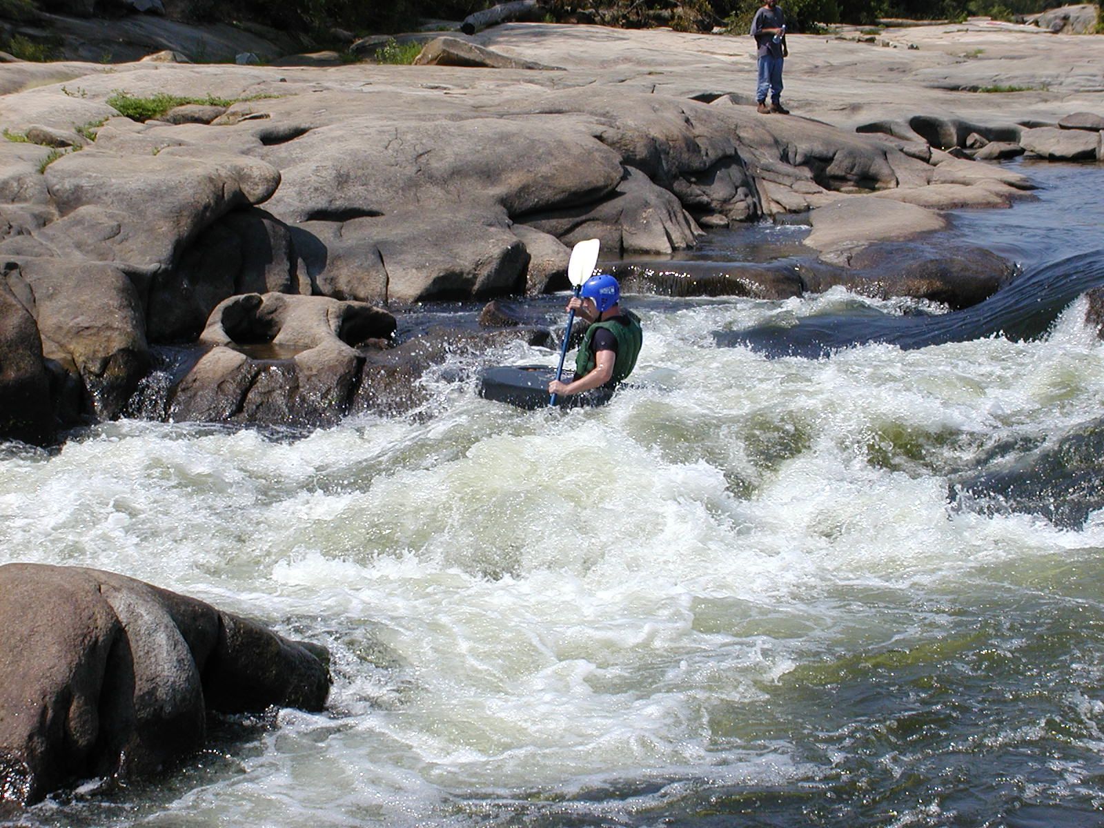A whitewater kayaker in a class III rapid.