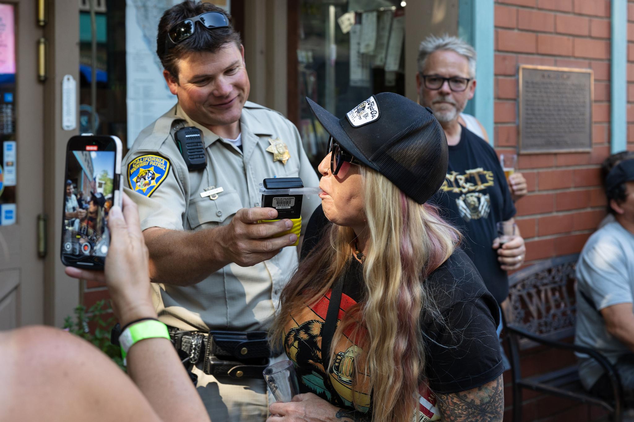 Highway Patrol Officer Kostik administers a breathalyzer test to a Brewfest attendee.