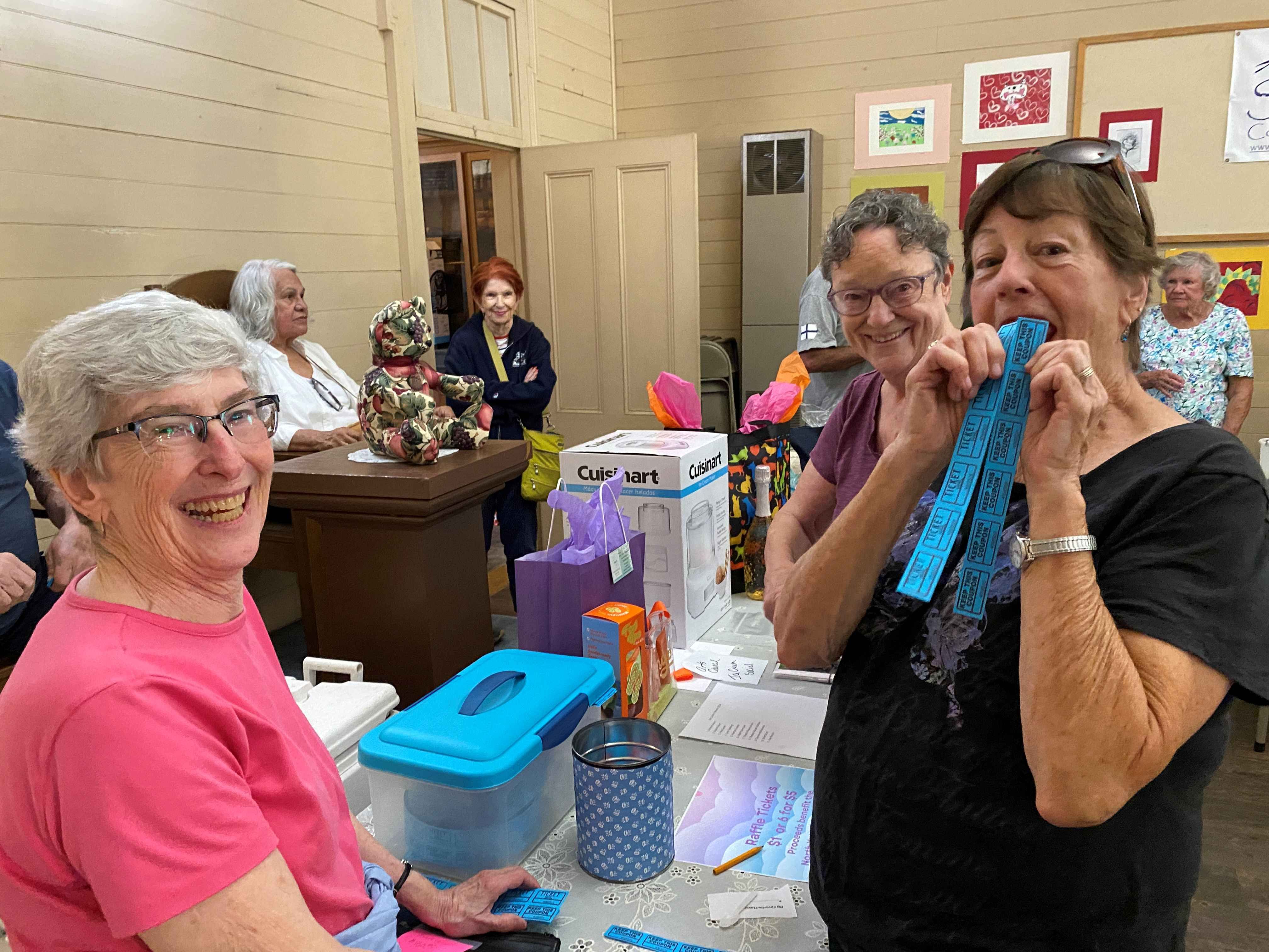 Jacie Epperson displays raffle tickets sold by Susan Hopkins (left) and Ingrid Larson (center)