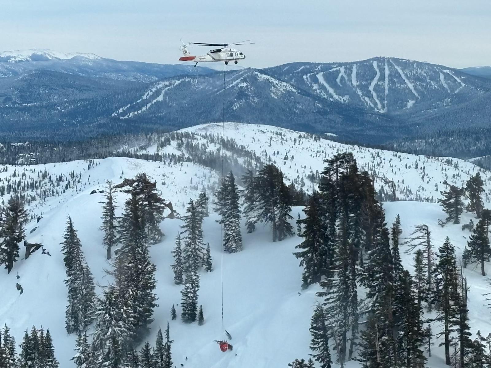 A helicopter performs avalanche mitigation on the slope where nine avalanche victims remained buried near Castle Peak. Credit: Nevada County Sheriff’s Office.