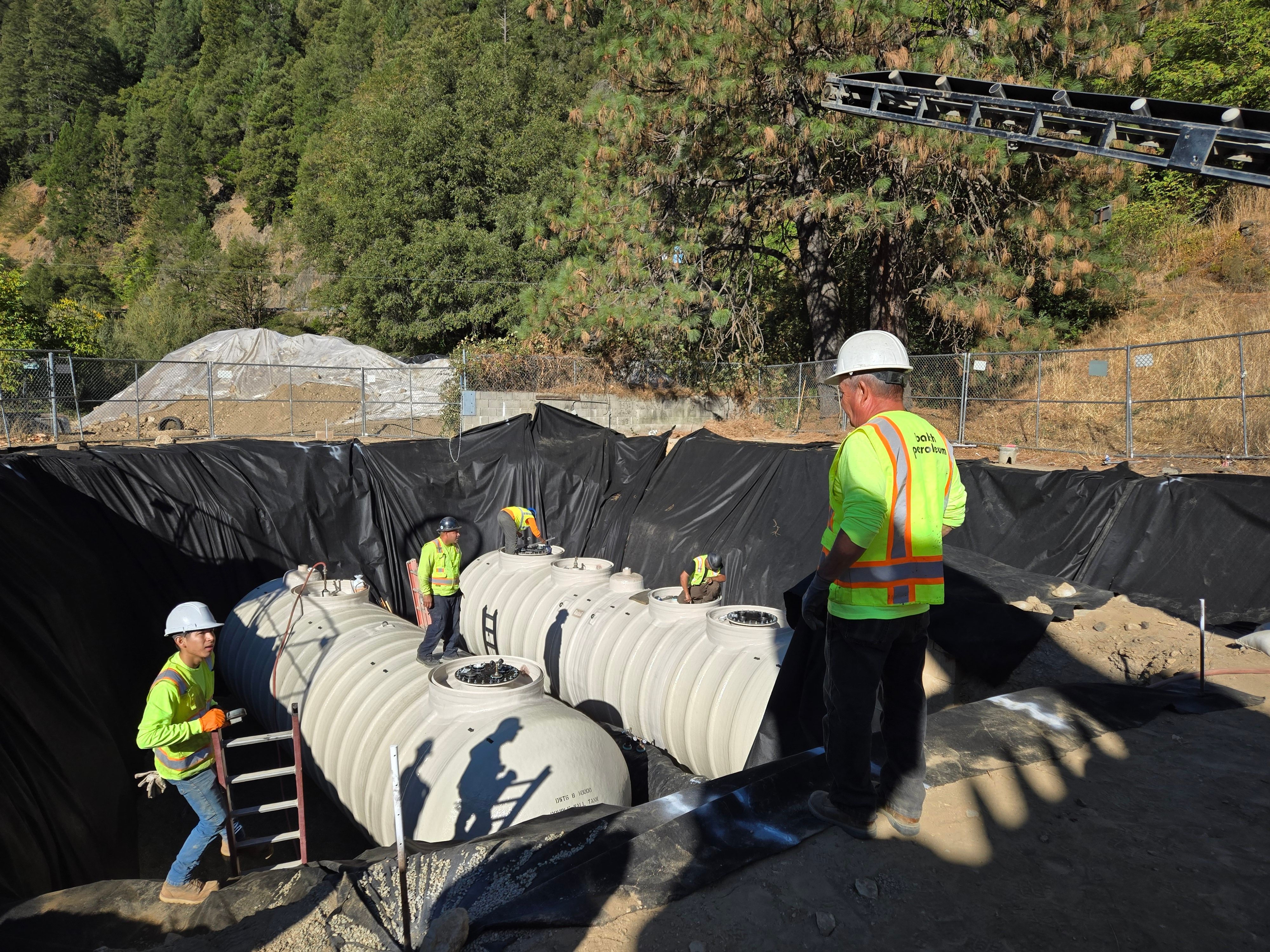 Workers install gas tanks for the Downieville Gas Station on Tuesday