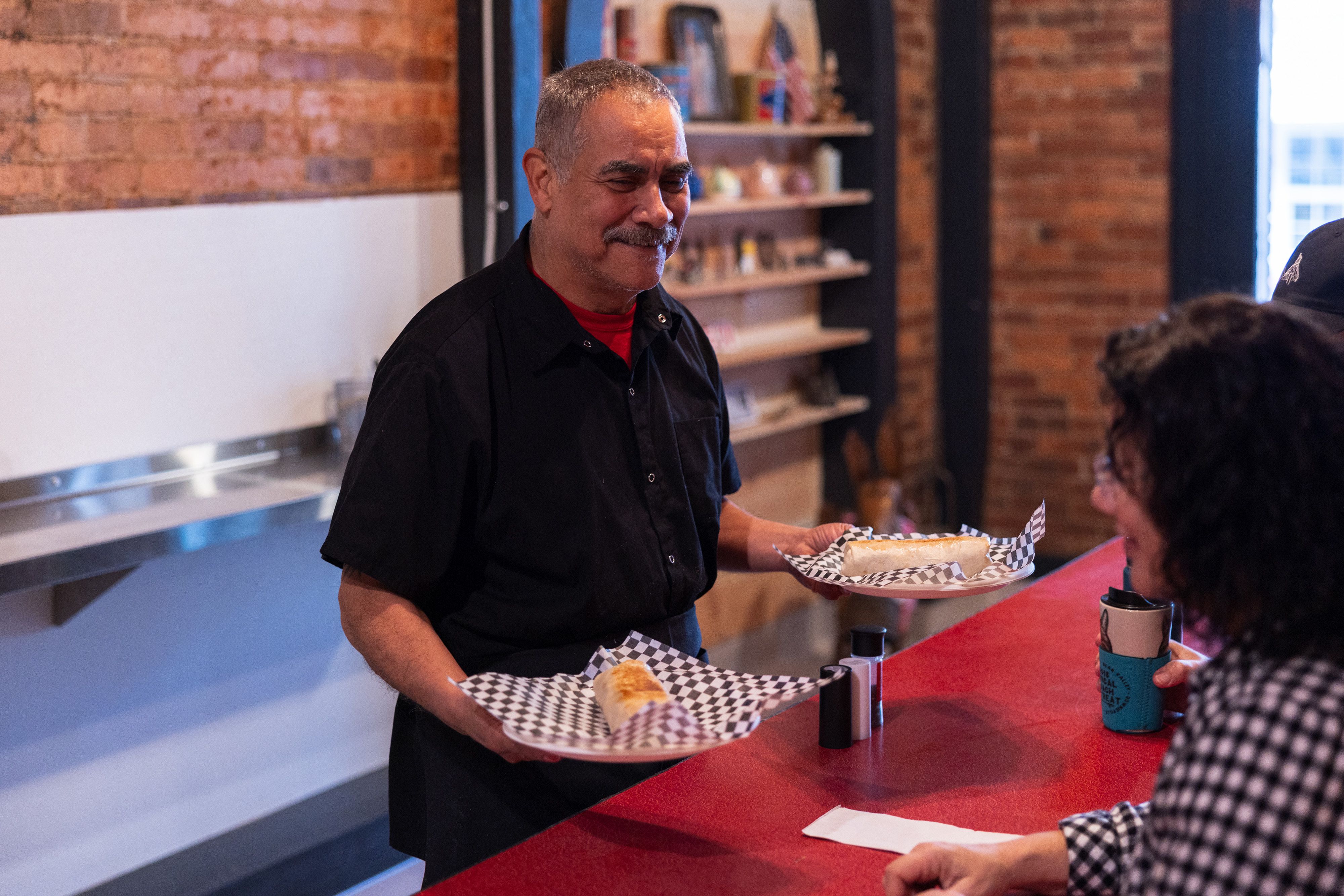 John Perez, owner of JADAA’s, serves breakfast burritos at his newly reopened restaurant.
