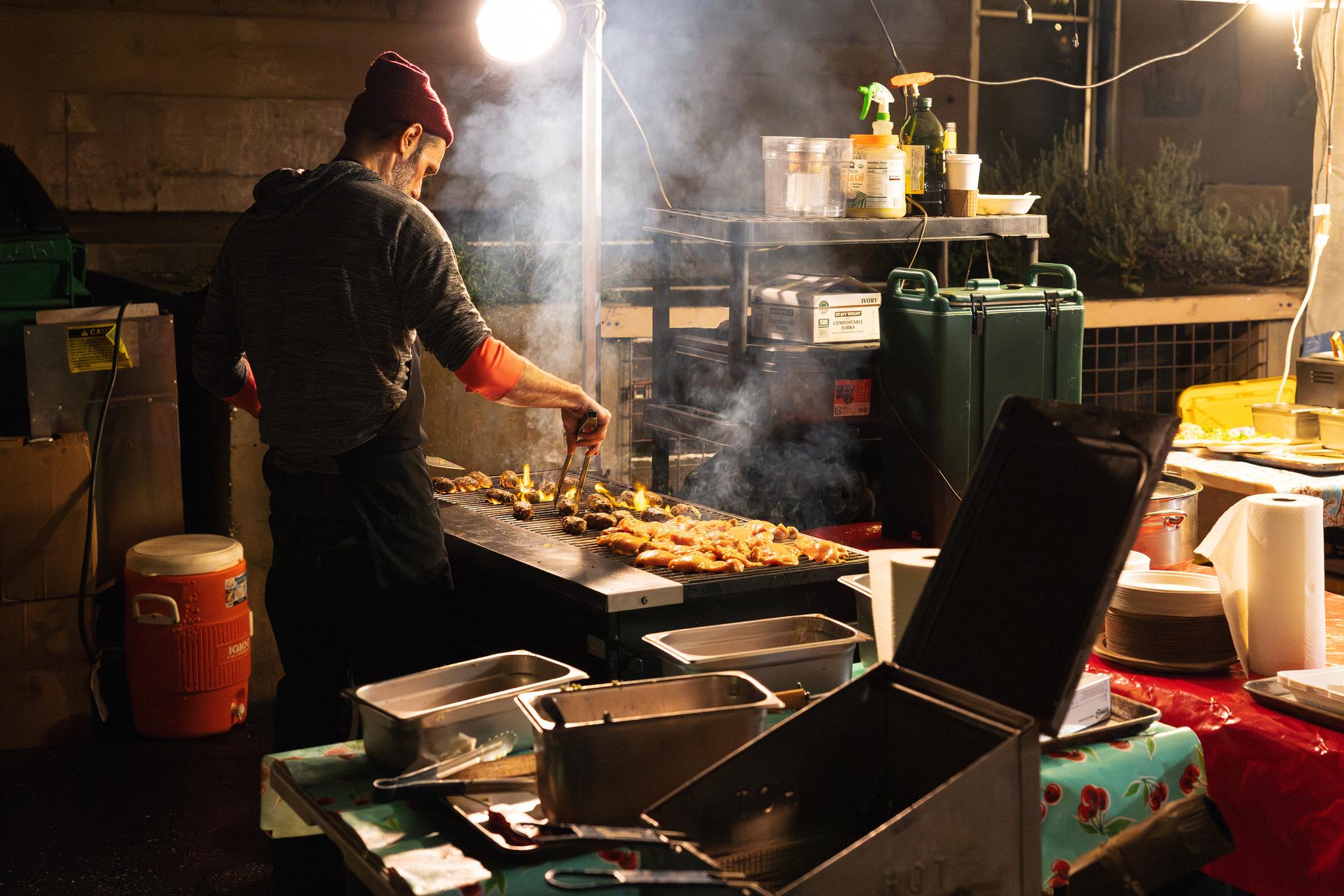 A vendor grills meats at the Victorian Christmas Food Court.