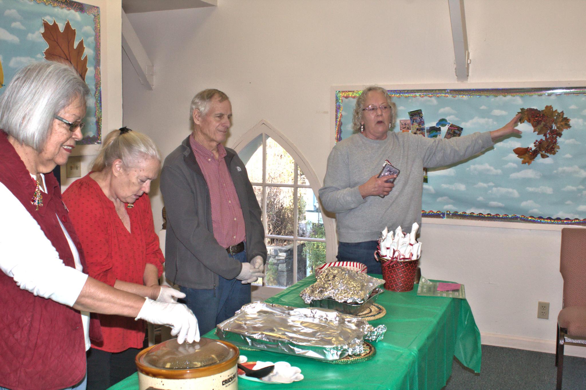 Sierra Roots’ Lunch Manager Dianne Weichel announces, “Lunch is ready!” as volunteers stand by to serve a hot home-cooked meal at the weekly free lunch offered to homeless persons and others in Nevada City. Photo by Tom Durkin.
