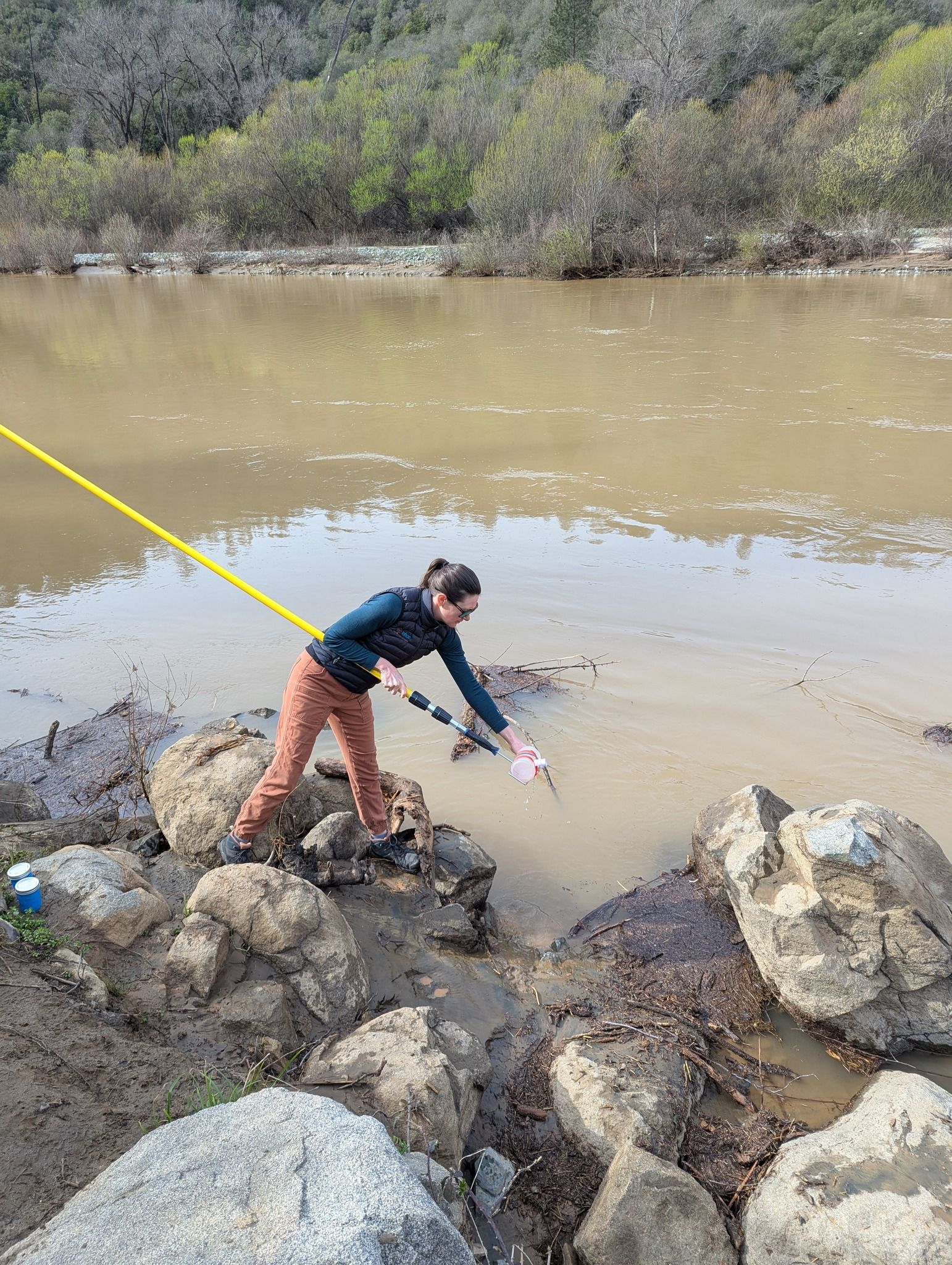 A SYRCL team member collects a sample from the river for independent analysis. Credit: SYRCL.