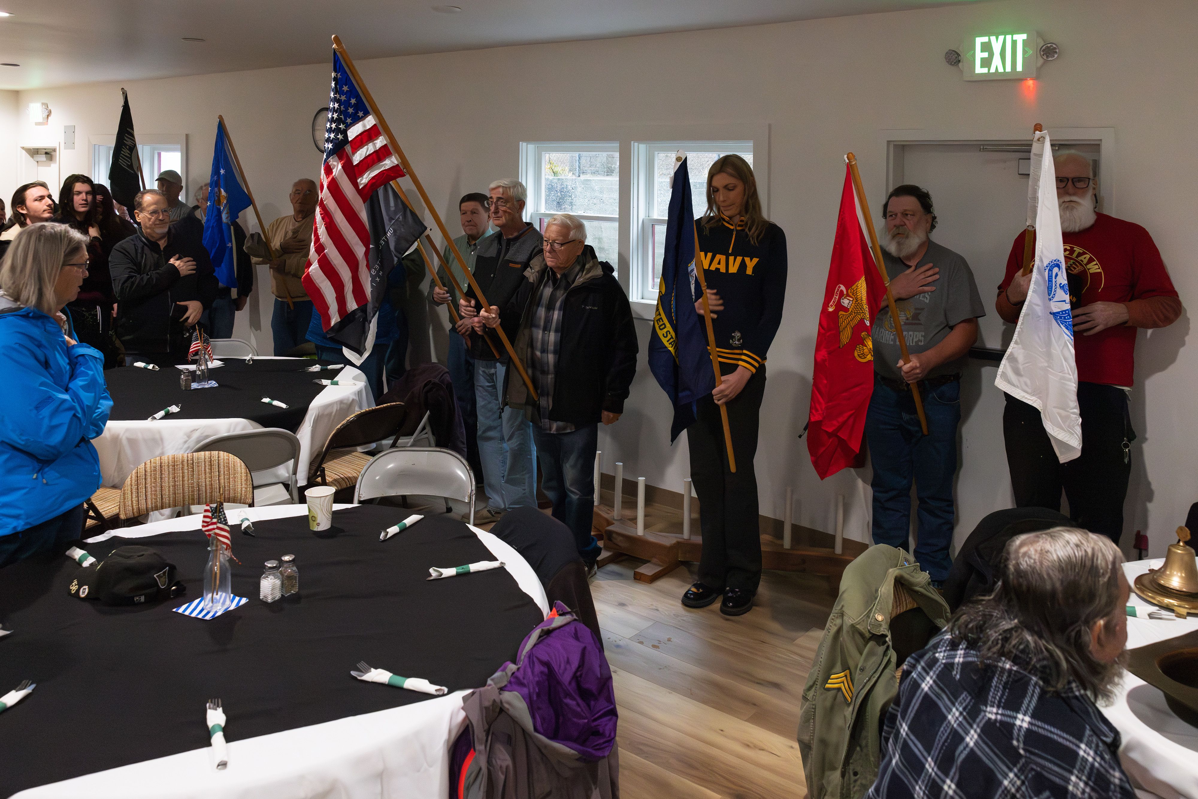 Veterans hold the flags of the United States and branches of the military as the national anthem plays in the Downieville Community Hall