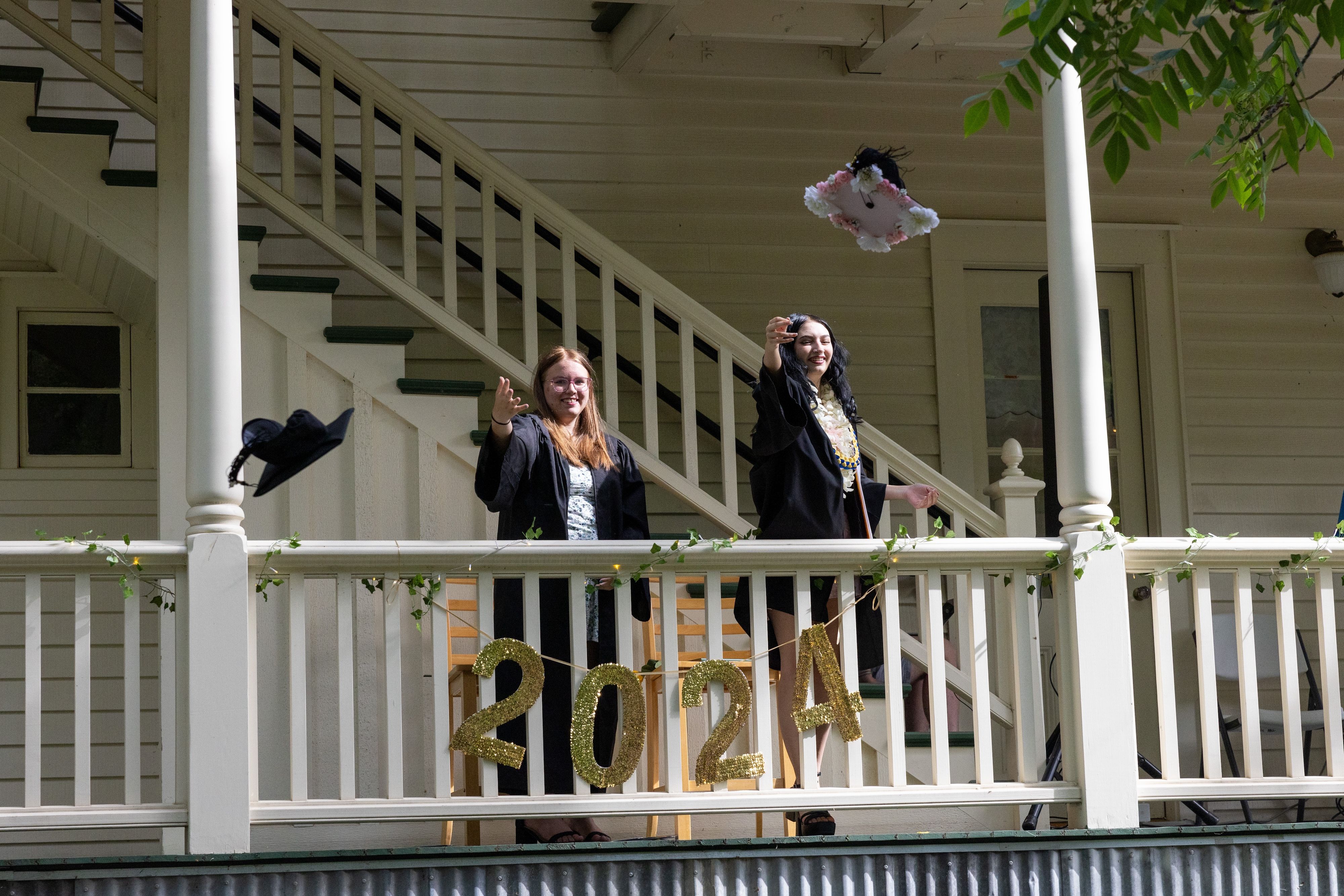 Natalie Diane Rust (left) and Abigail Cecilia Sainsbury (right), Downieville High School class of 2024, throw their graduation caps