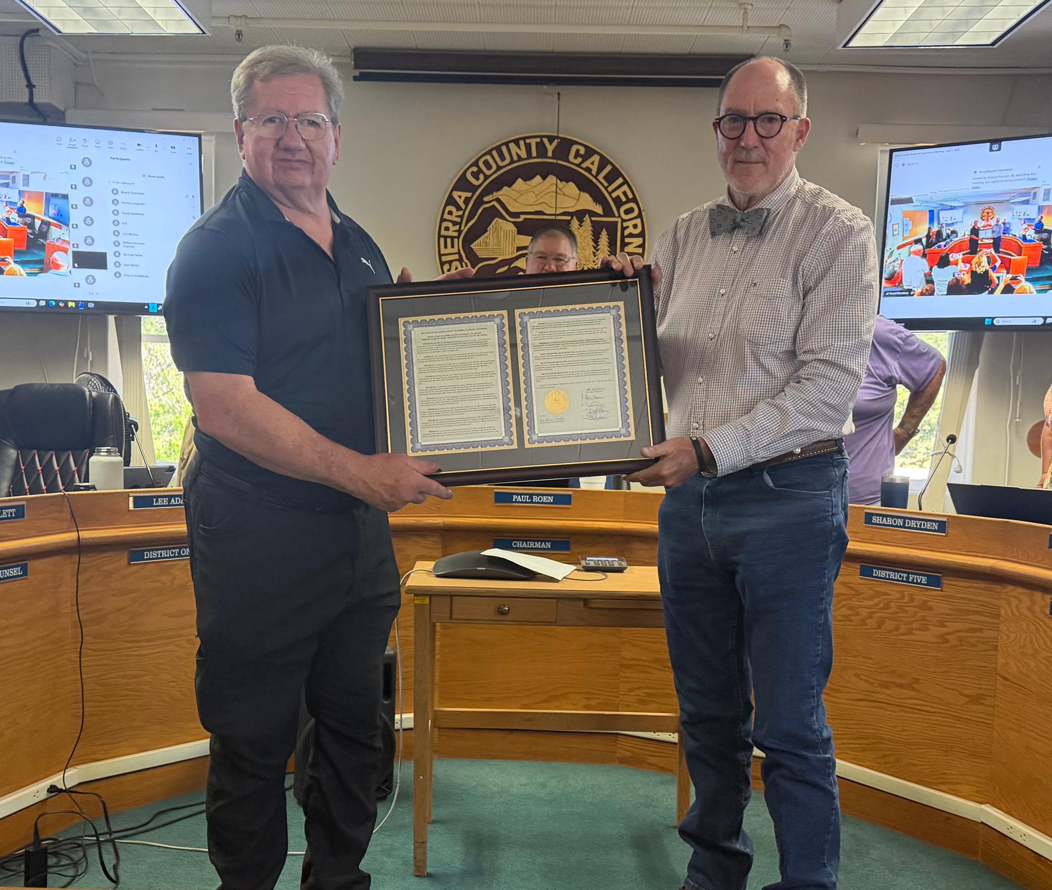 Lee Brown (left) receives a resolution of appreciation from the Board of Supervisors, presented by Lee Adams.